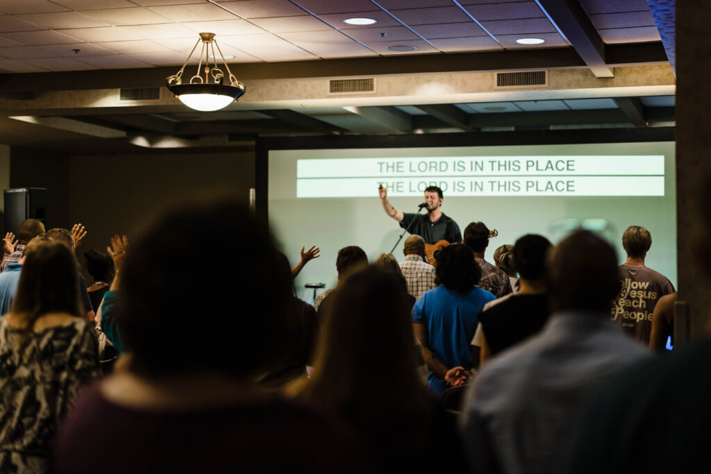 Picture of worship gathering and hands lifted on a Sunday at church